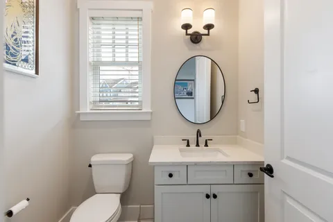 a bathroom with a toilet a sink and mirror