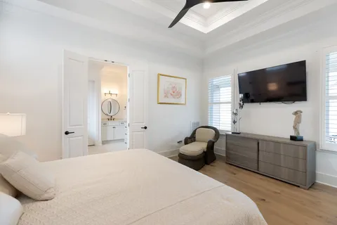 a bedroom with a bed a chair and the flat screen tv