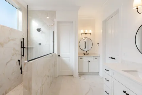 a bathroom with a sink a mirror a vanity and a shower