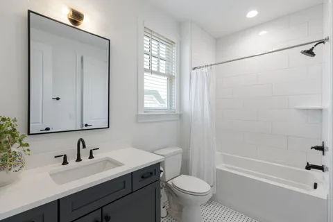 a bathroom with a sink toilet a mirror and shower
