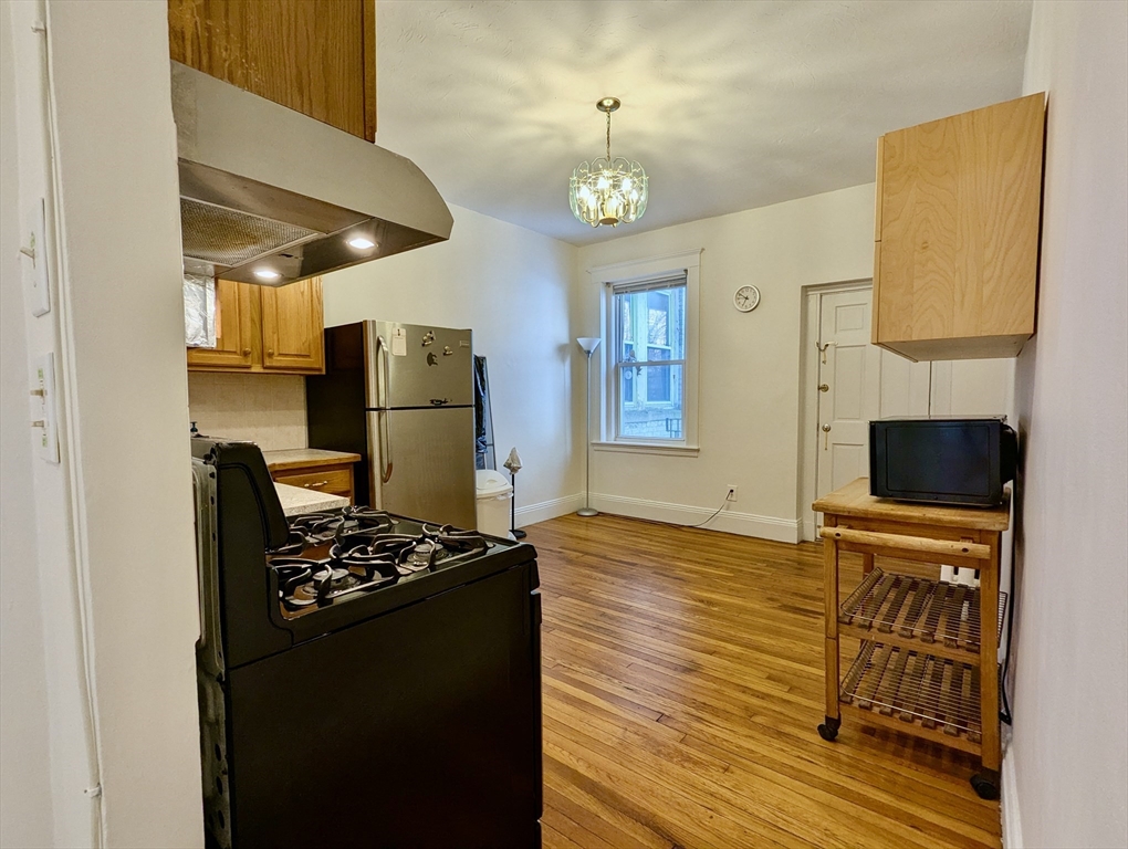 21 Westbourne Terrace, Unit 3 Brookline, MA 02446 - Photo 12 of 23 a kitchen with sink cabinets and wooden floor