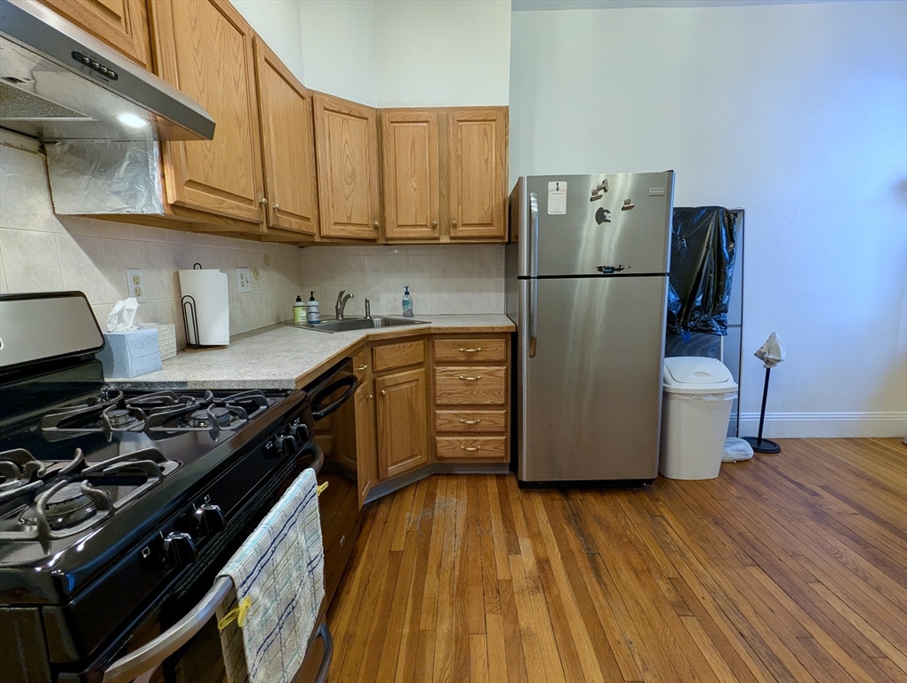21 Westbourne Terrace, Unit 3 Brookline, MA 02446 - Photo 17 of 23 a kitchen with wooden cabinets and a stove top oven