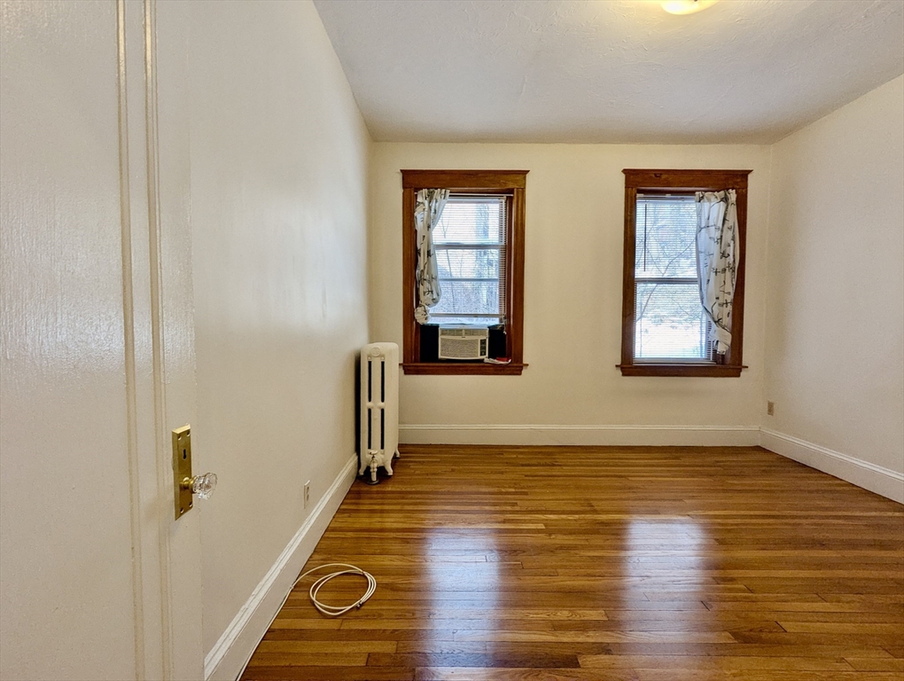 21 Westbourne Terrace, Unit 3 Brookline, MA 02446 - Photo 19 of 23 a view of an empty room with wooden floor and a window