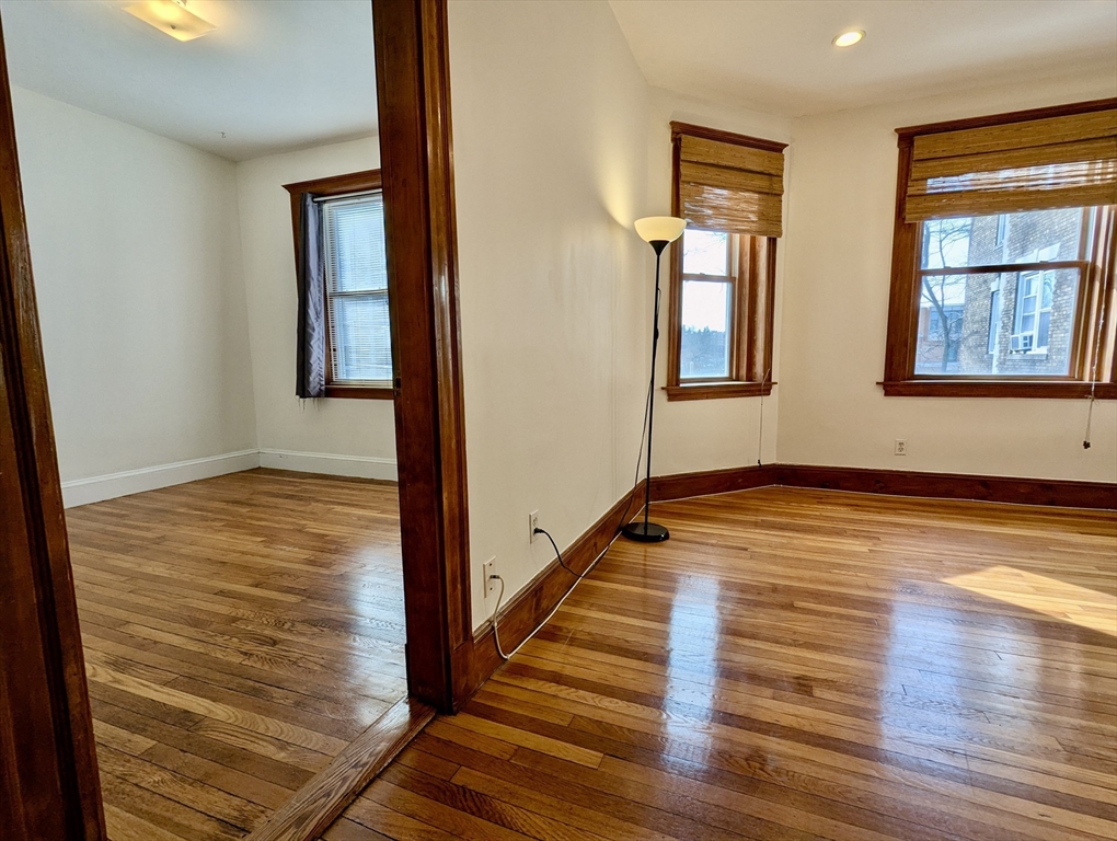 21 Westbourne Terrace, Unit 3 Brookline, MA 02446 - Photo 6 of 23 a view of an empty room with wooden floor and a window