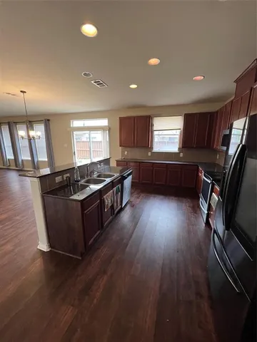 a kitchen with wooden floors and wooden cabinets