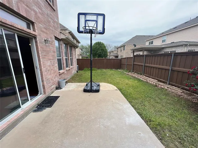 a view of a chair and table in backyard of the house
