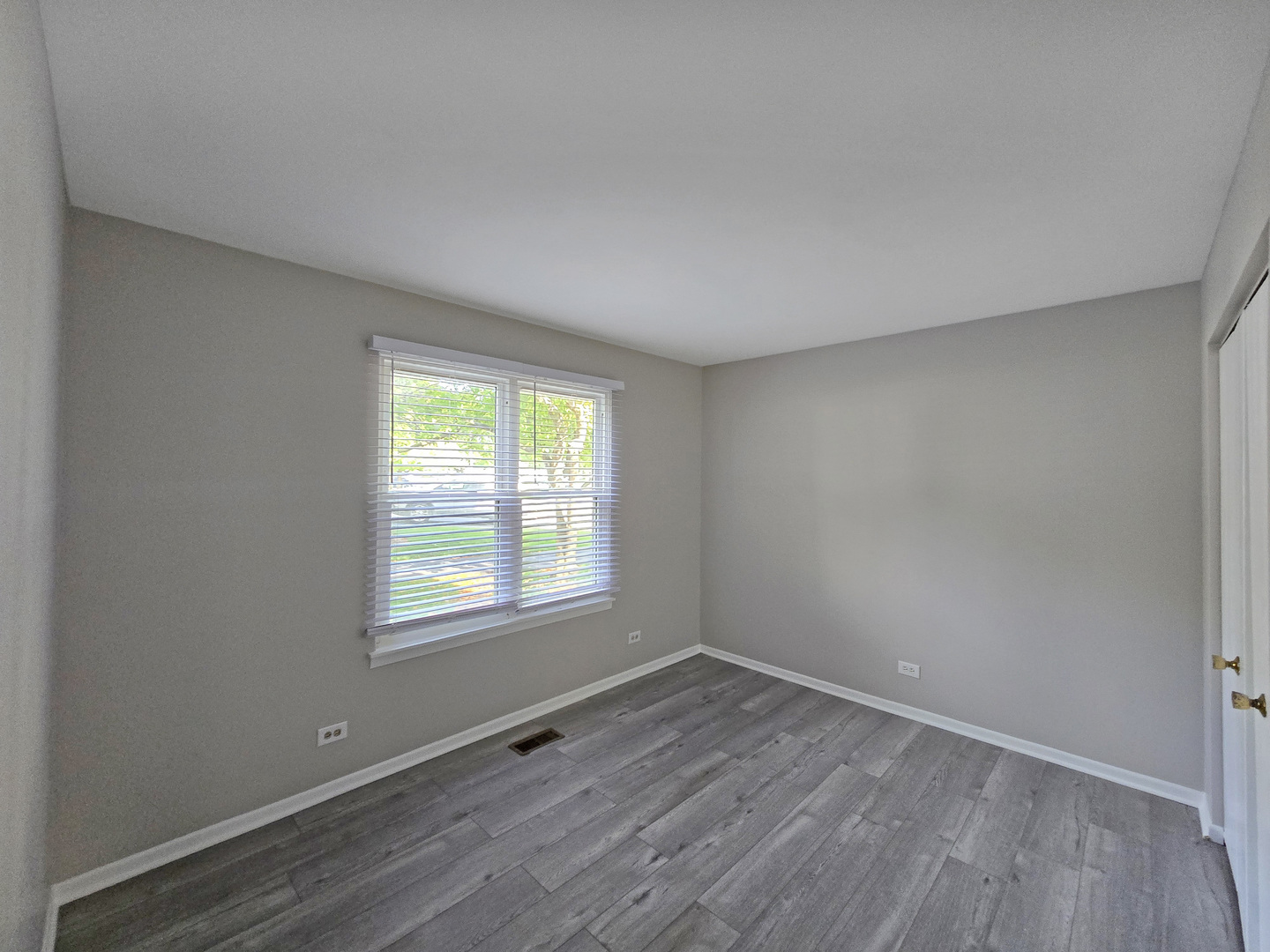 1349 Ridgefield Circle, Unit 1349 Carol Stream, IL 60188 - Photo 7 of 9 an empty room with wooden floor and windows