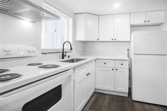 a kitchen with white cabinets and white appliances