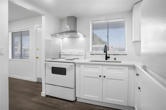 a kitchen with cabinets appliances and a wooden floor