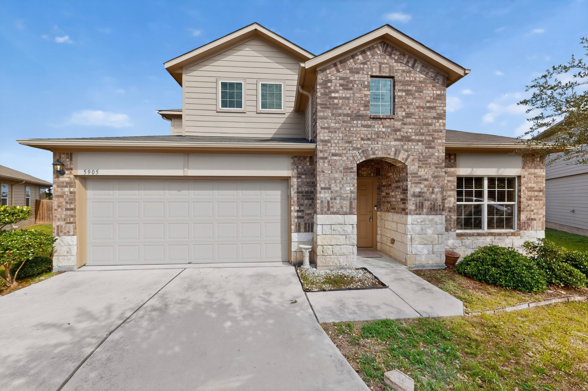 5905 Diamondleaf Bend Austin, TX 78724 - Photo 2 of 38 Two-story residence featuring a brick and stone facade, a two-car garage, and a concrete driveway