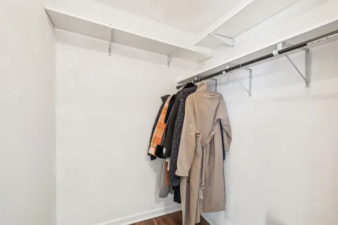 a view of walk in closet with clothes and shoes