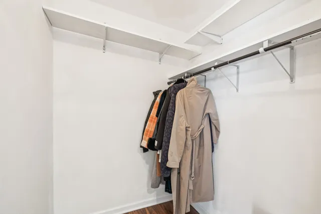 a view of walk in closet with clothes and shoes