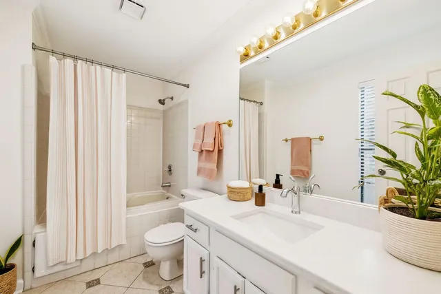 a bathroom with a sink a toilet and shower curtain