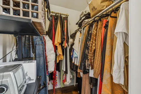 a view of walk in closet with clothes and shoes