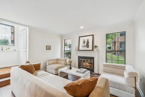 a living room with furniture fireplace and a window