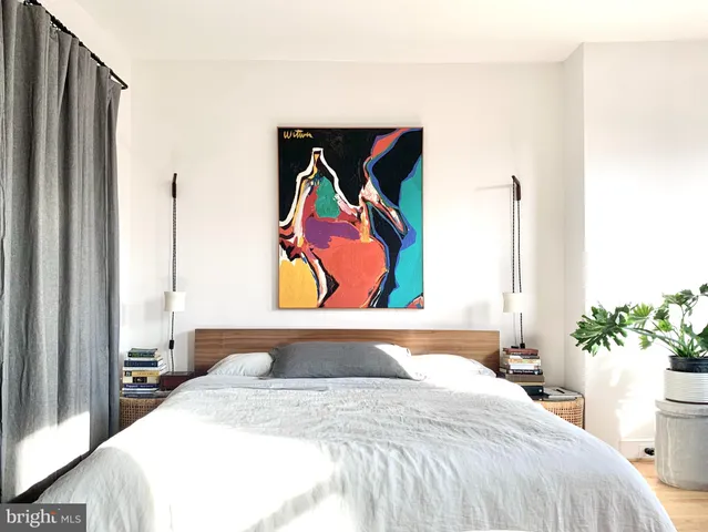 a bedroom with a bed and a painting on the wall