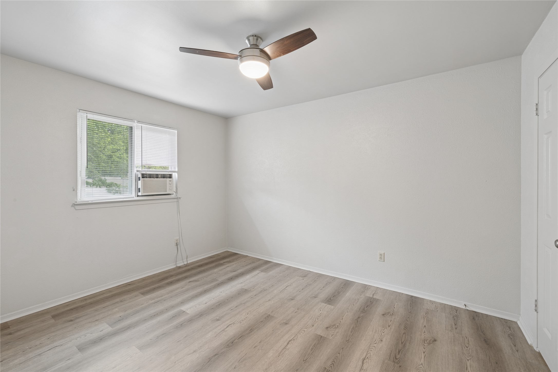 820 Sahara Avenue, Unit B Austin, TX 78745 - Photo 8 of 29 Spare room featuring light wood-type flooring, ceiling fan, and cooling unit