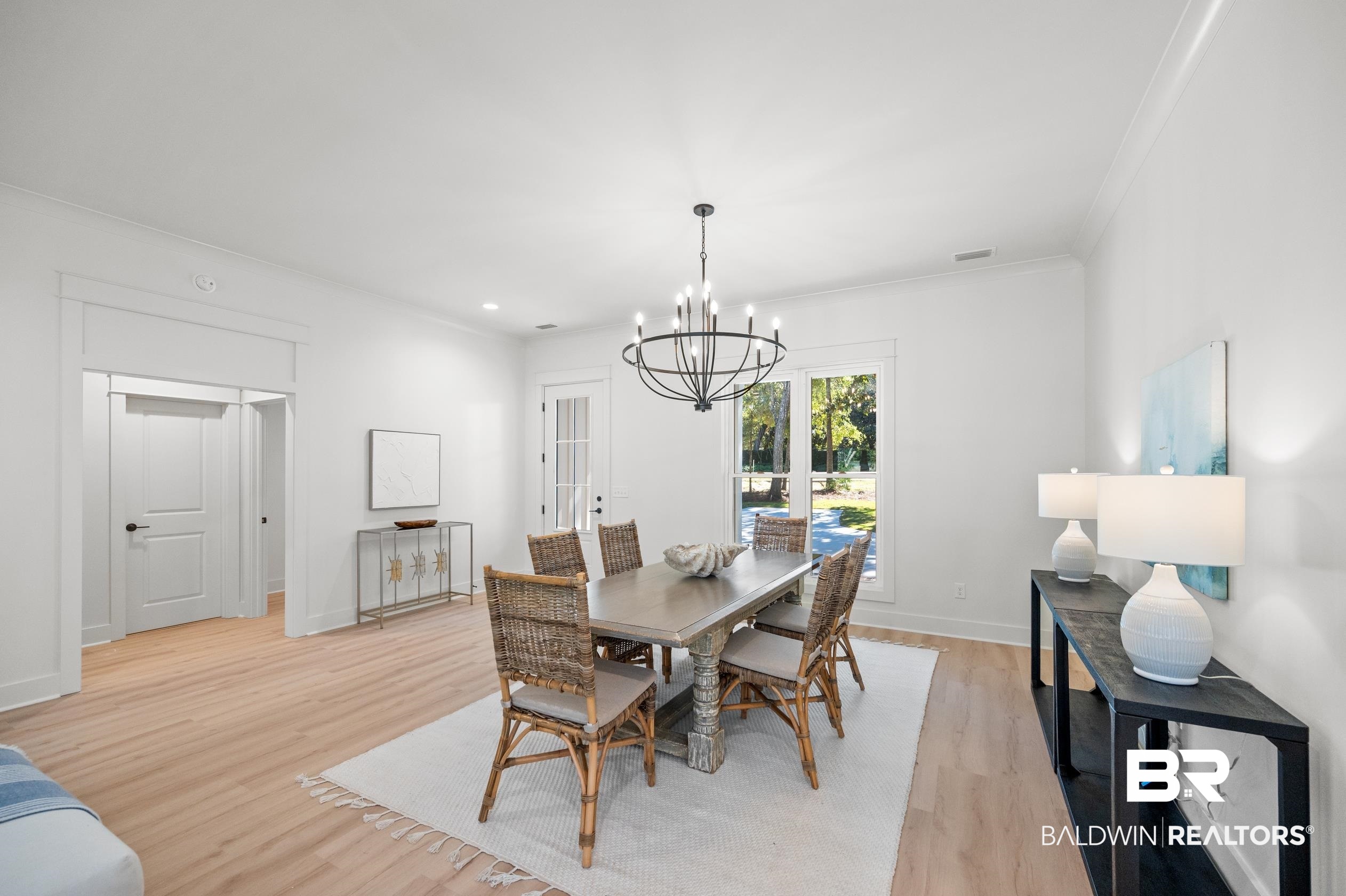 28889 Canal Road Orange Beach, AL 36561 - Photo 29 of 55 Dining room featuring a chandelier, light hardwood / wood-style floors, and crown molding