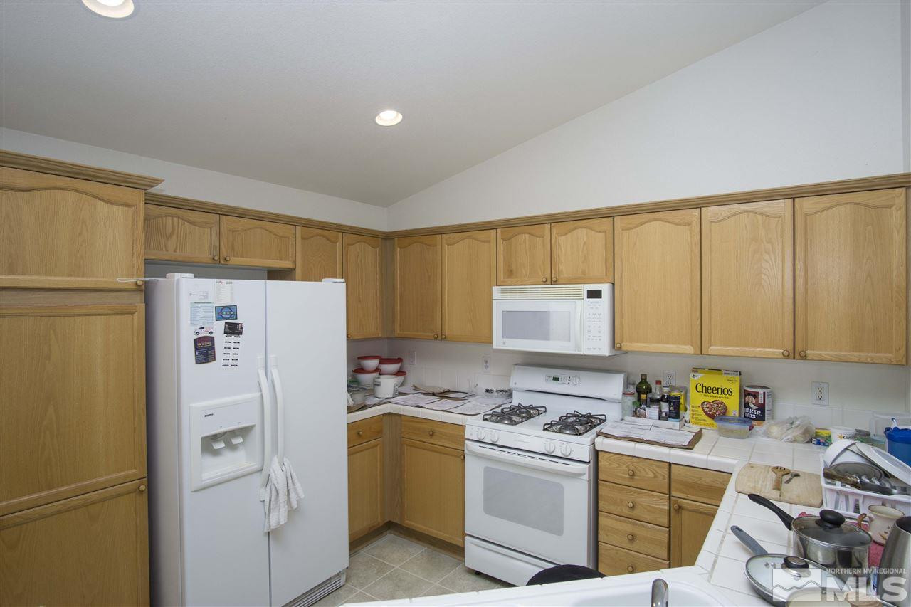 9428 Mammoth Drive Reno, NV 89521 - Photo 4 of 18 a kitchen with a refrigerator a stove a sink and cabinets