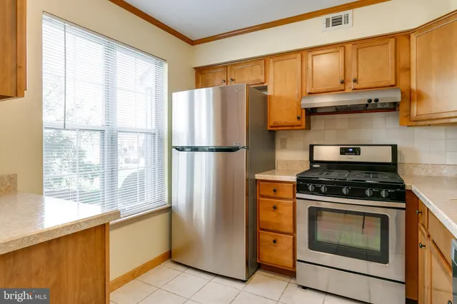 a kitchen with stainless steel appliances granite countertop a refrigerator stove and sink