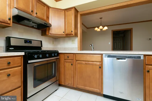 a kitchen with stainless steel appliances a stove a microwave and white cabinets