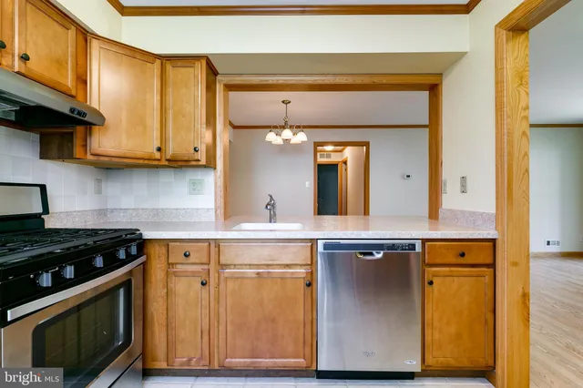 a kitchen with granite countertop wooden cabinets and a stove top oven