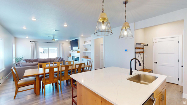 1127 4240 North Enoch, UT 84721 - Photo 56 of 56 Kitchen featuring light wood-type flooring, open floor plan, hanging light fixtures, and an island with sink