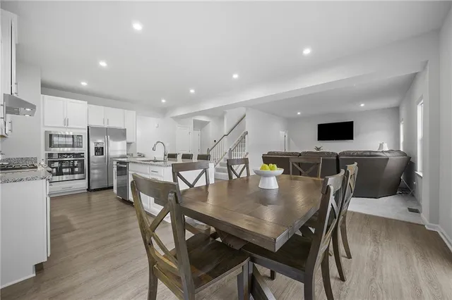 a kitchen with a dining table chairs and refrigerator