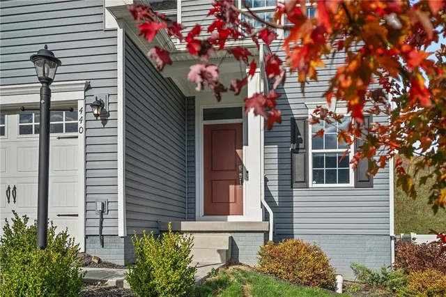a front view of a house with plants