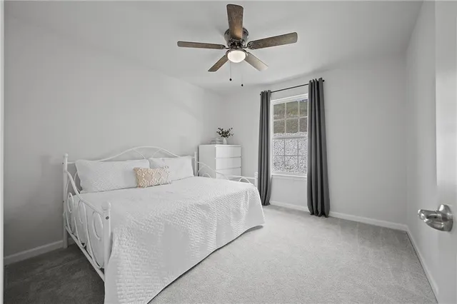 a bedroom with a bed and a ceiling fan