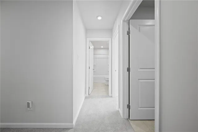 a view of a hallway with white walls and closet