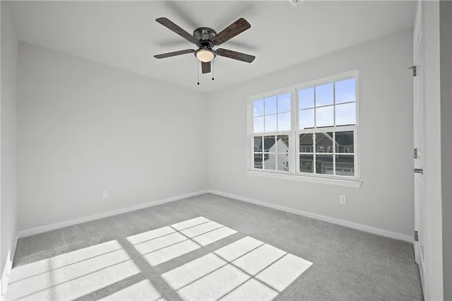 an empty room with windows and ceiling fan