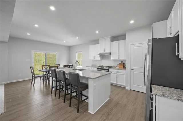 a kitchen with a table chairs refrigerator and microwave