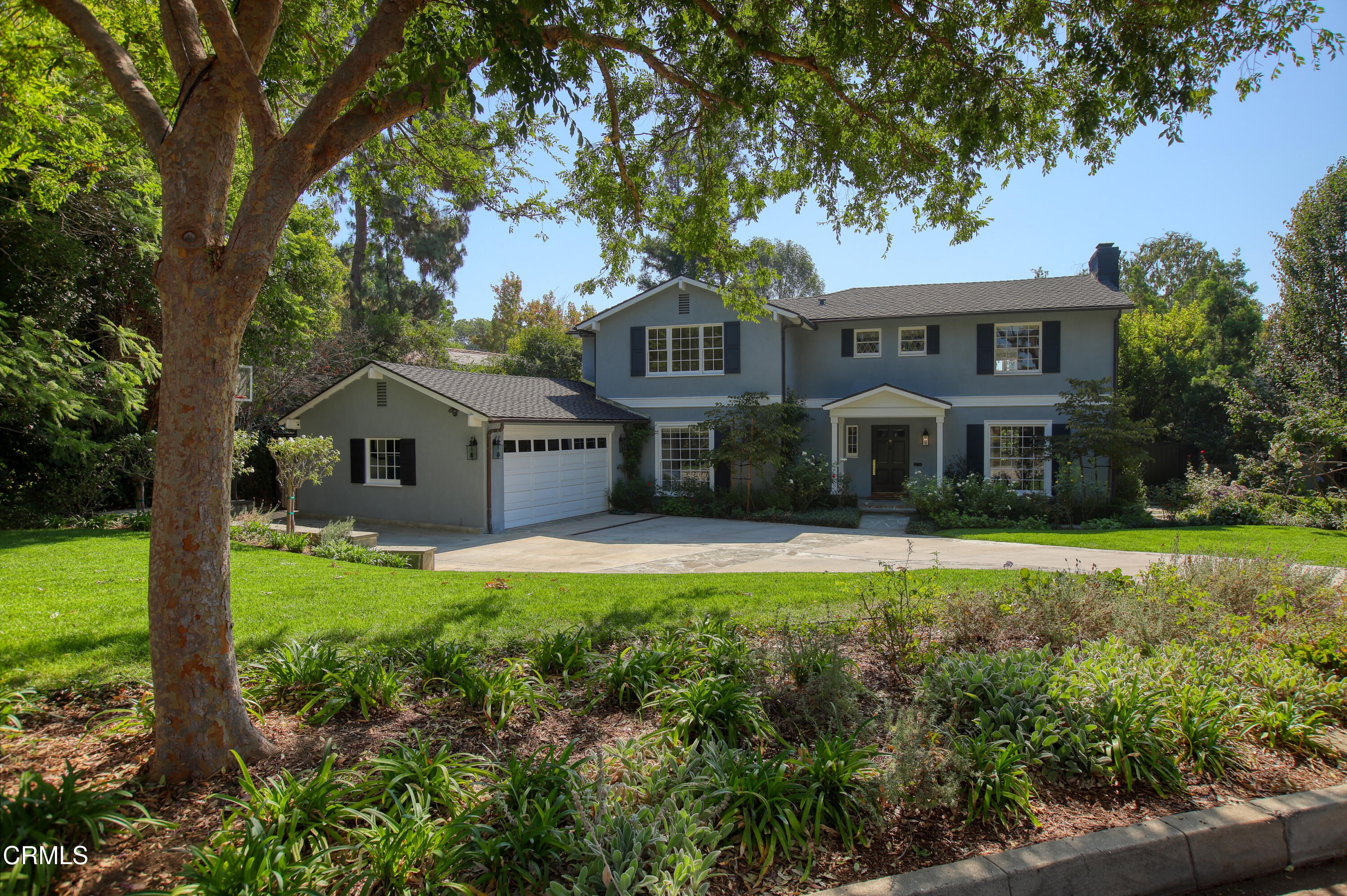 a front view of a house with a yard and trees