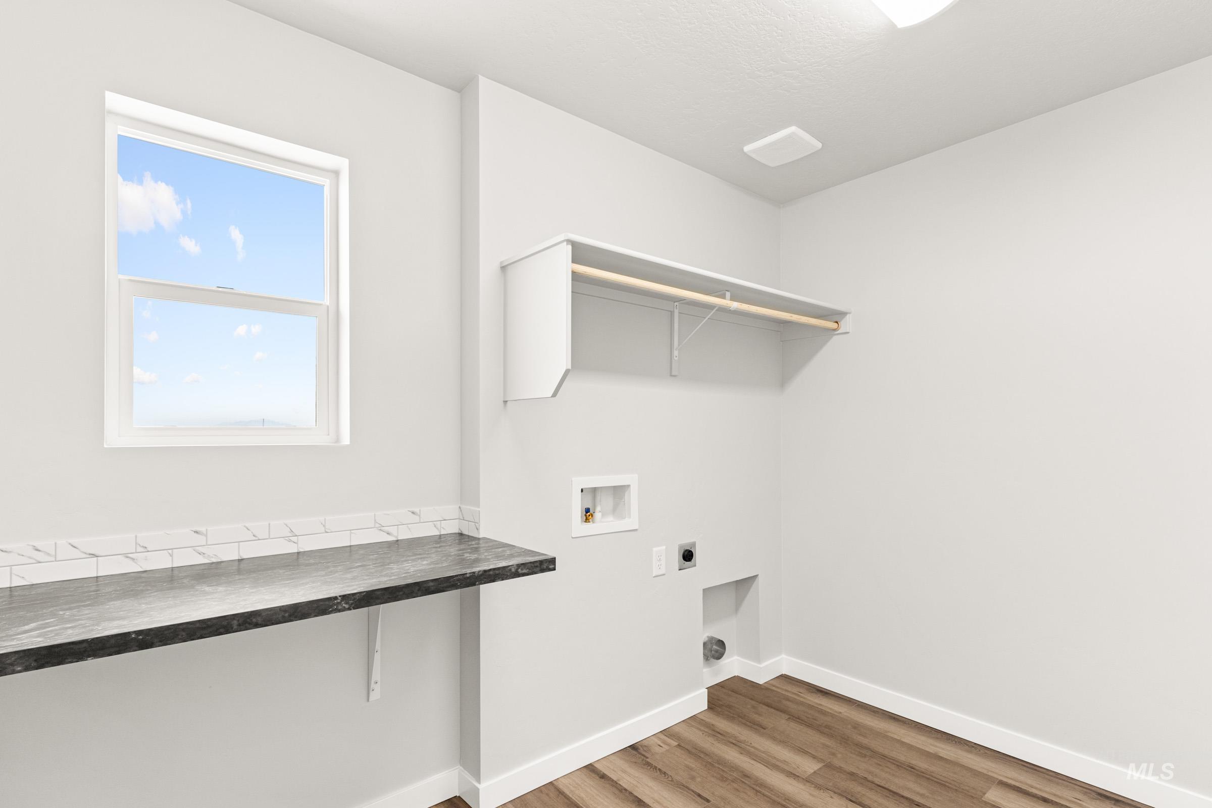 12830 Ropers Street Nampa, ID 83651 - Photo 14 of 18 Utility room featuring wood-finish flooring, a double-hung window, and a built-in countertop with subway tile backsplash