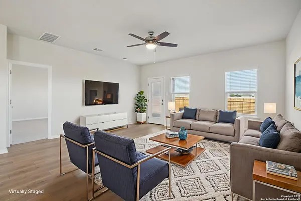 a living room with furniture a flat screen tv and a window