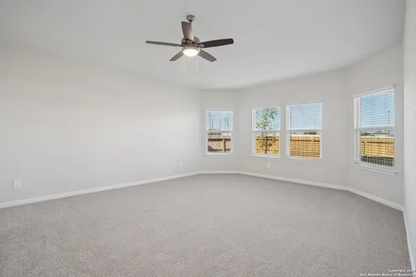 a spacious bedroom with a bed a couch and a potted plant