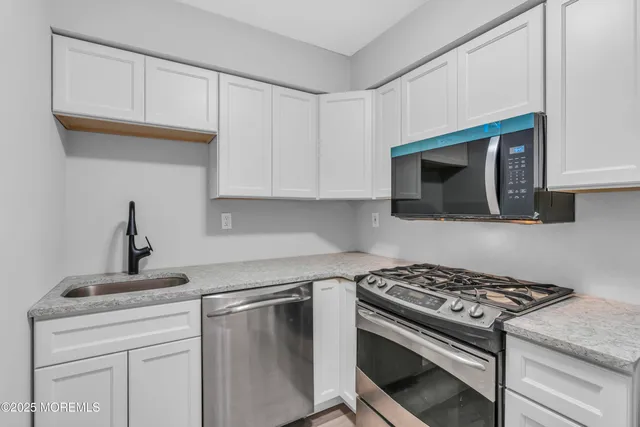 a kitchen with white cabinets and appliances