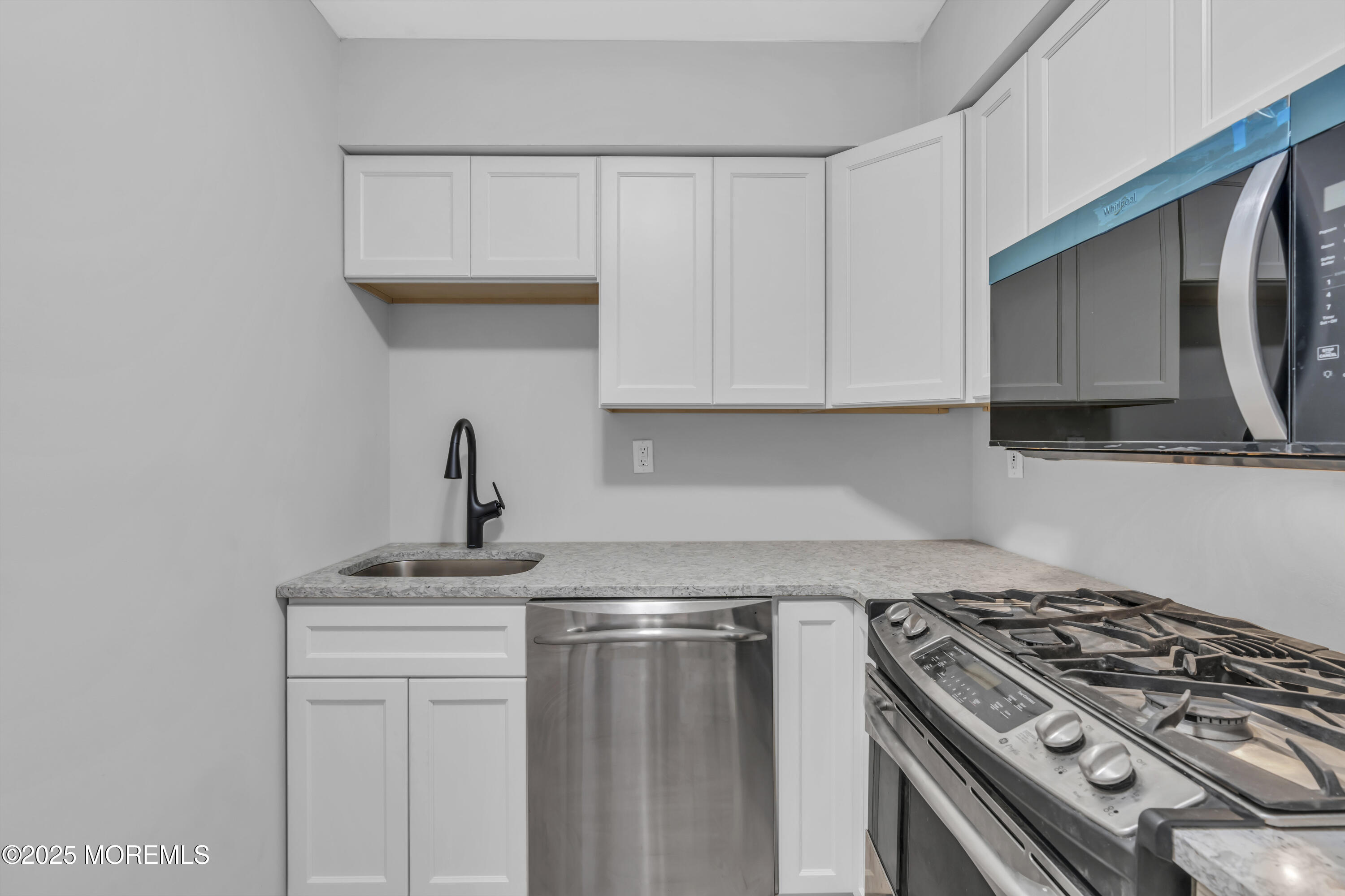 213 Main Street, Unit 17 Keansburg, NJ 07734 - Photo 13 of 15 a kitchen with stainless steel appliances granite countertop a sink a stove and microwave