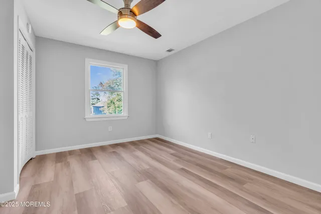 an empty room with a window and a ceiling fan