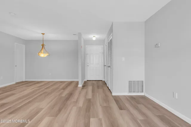 a view of empty room with wooden floor and window