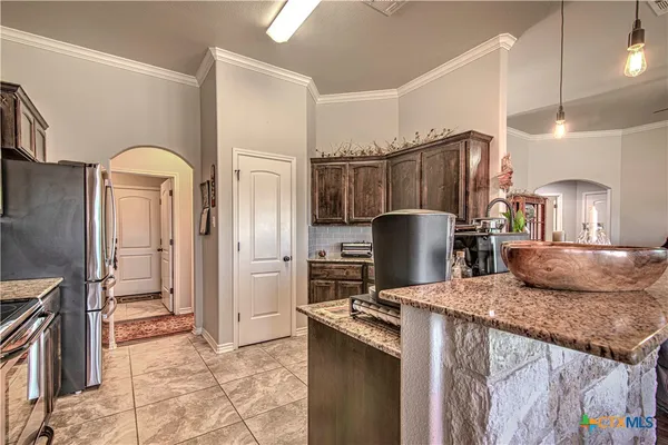 a kitchen with granite countertop a stove and a refrigerator