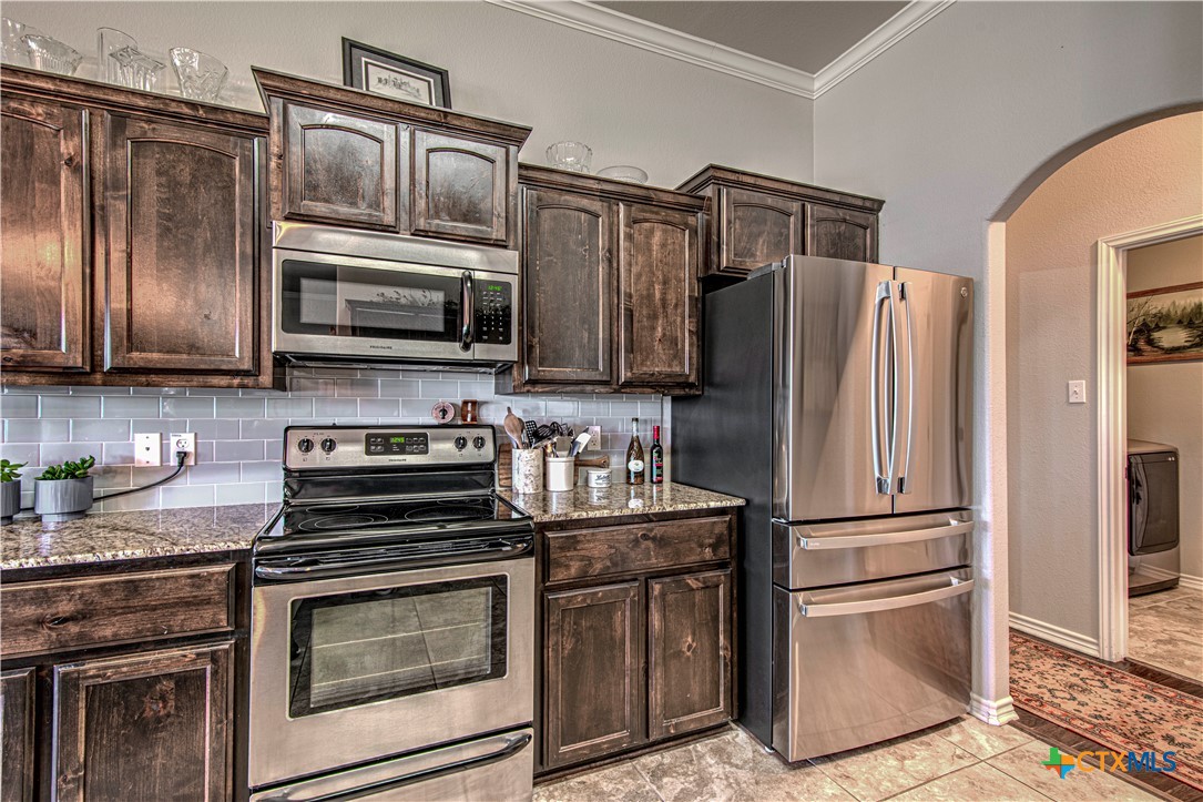 412 Dandridge Drive Temple, TX 76502 - Photo 19 of 44 a kitchen with granite countertop stainless steel appliances and wooden cabinets