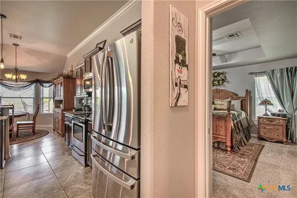 a kitchen with stainless steel appliances granite countertop a refrigerator and a stove top oven