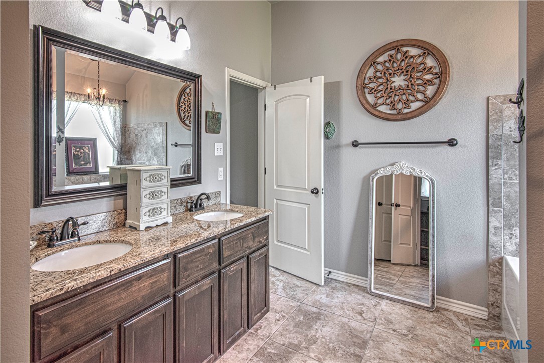 412 Dandridge Drive Temple, TX 76502 - Photo 23 of 44 a bathroom with a granite countertop sink and a mirror
