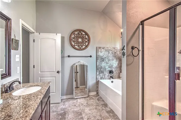 a spacious bathroom with a granite countertop tub sink and mirror