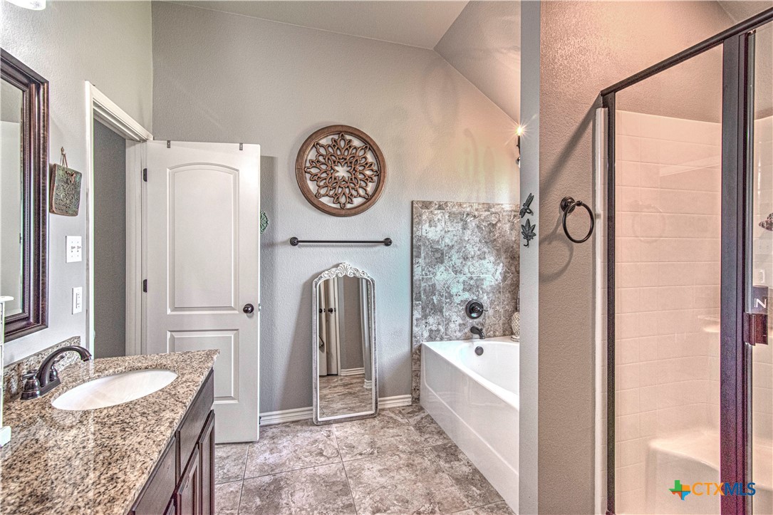 412 Dandridge Drive Temple, TX 76502 - Photo 26 of 44 a spacious bathroom with a granite countertop tub sink and mirror