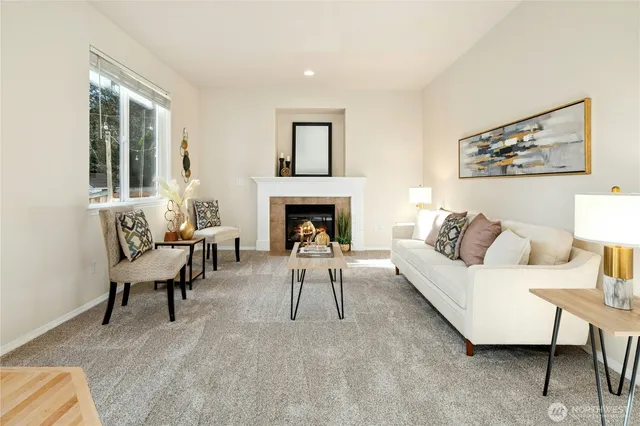 a living room with furniture two windows and a fireplace