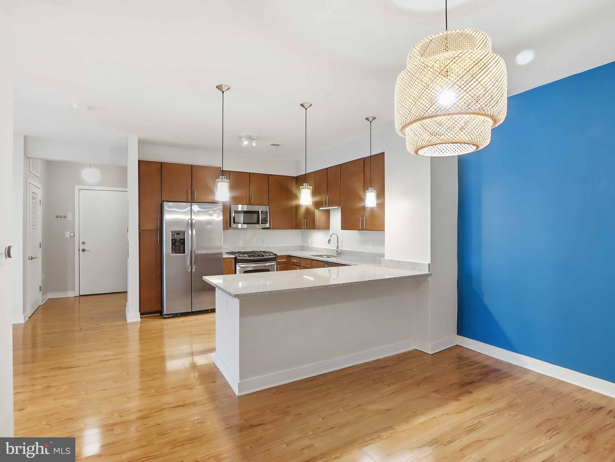 8005 13th Street, Unit 411 Silver Spring, MD 20910 - Photo 23 of 33 a kitchen with stainless steel appliances granite countertop a sink a stove and a wooden floors