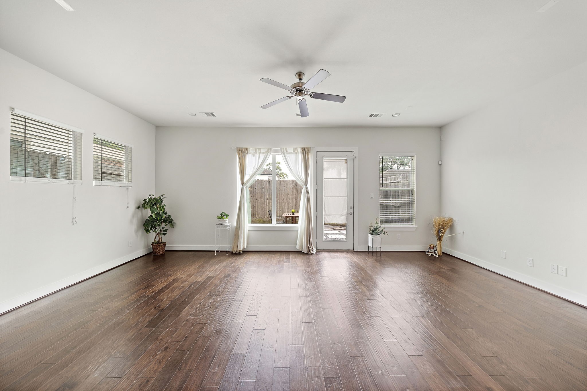 9517 Cedarpost Square Street Houston, TX 77055 - Photo 4 of 20 an empty room with wooden floor chandelier fan and windows